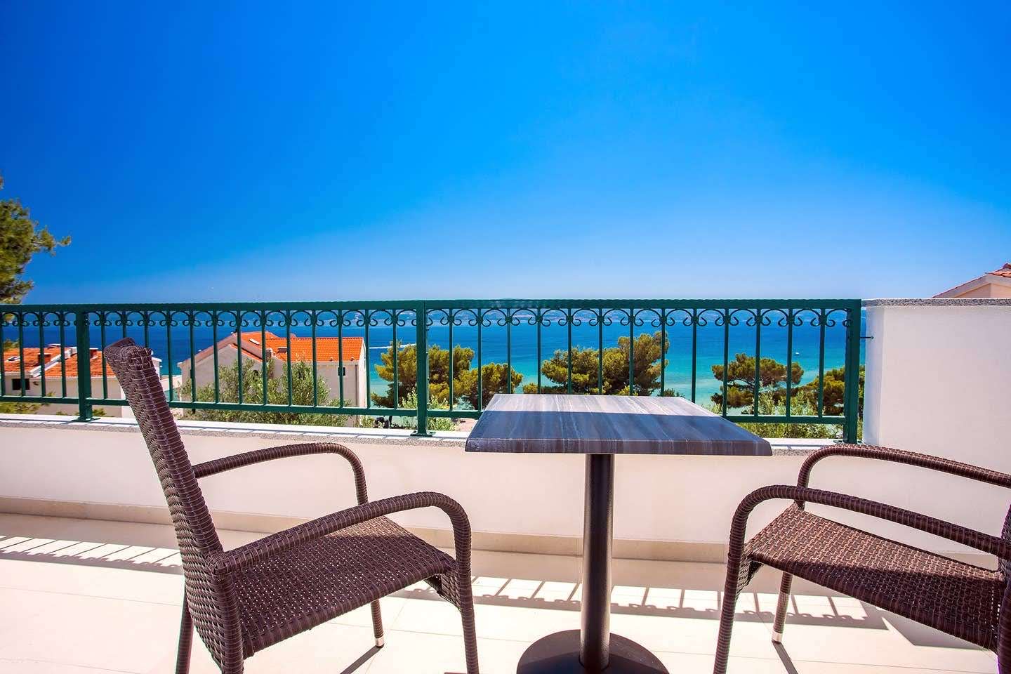Upper balcony with table and chairs overlooking the sea