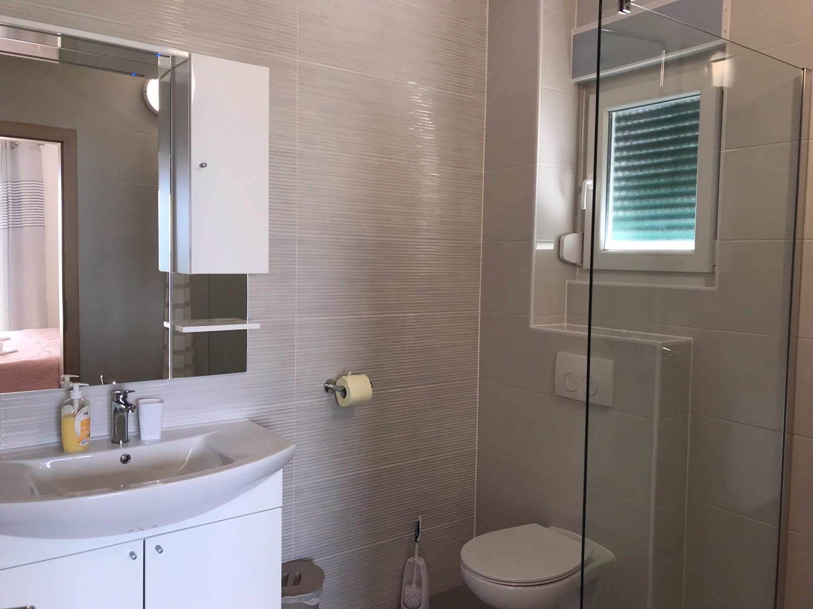 En-suite bathroom with sink, toilet, and walk-in shower