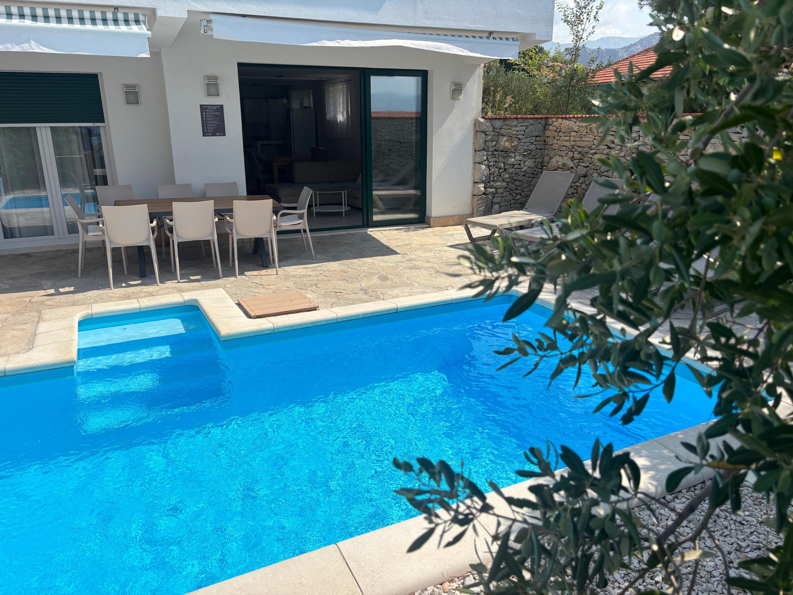Poolside view with new sun loungers and outdoor dining table